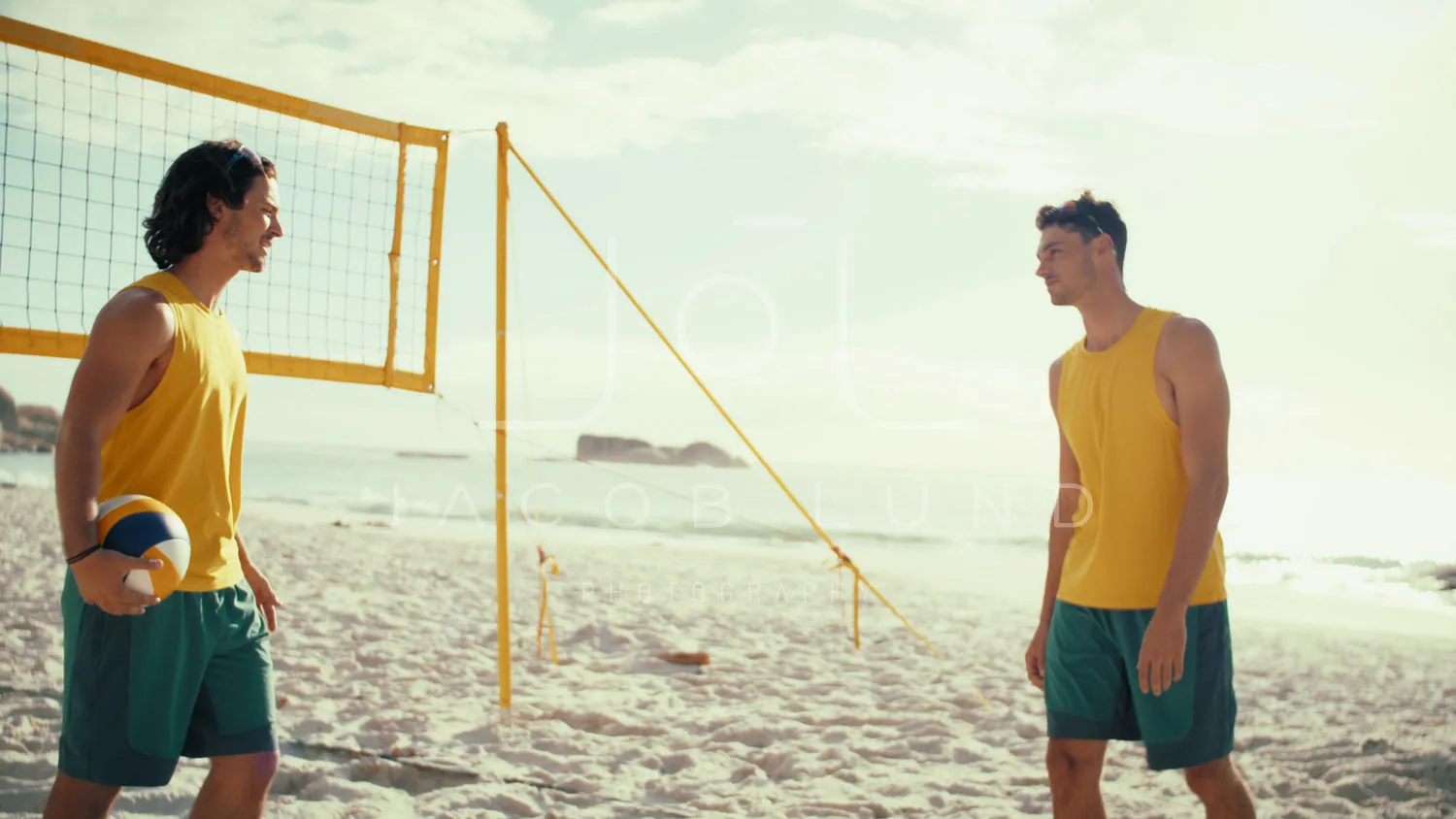 Australian male athletes posing on the beach volleyball court before a match