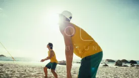 Dynamic handheld shot of professional sportsmen displaying teamwork on beach volleyball court